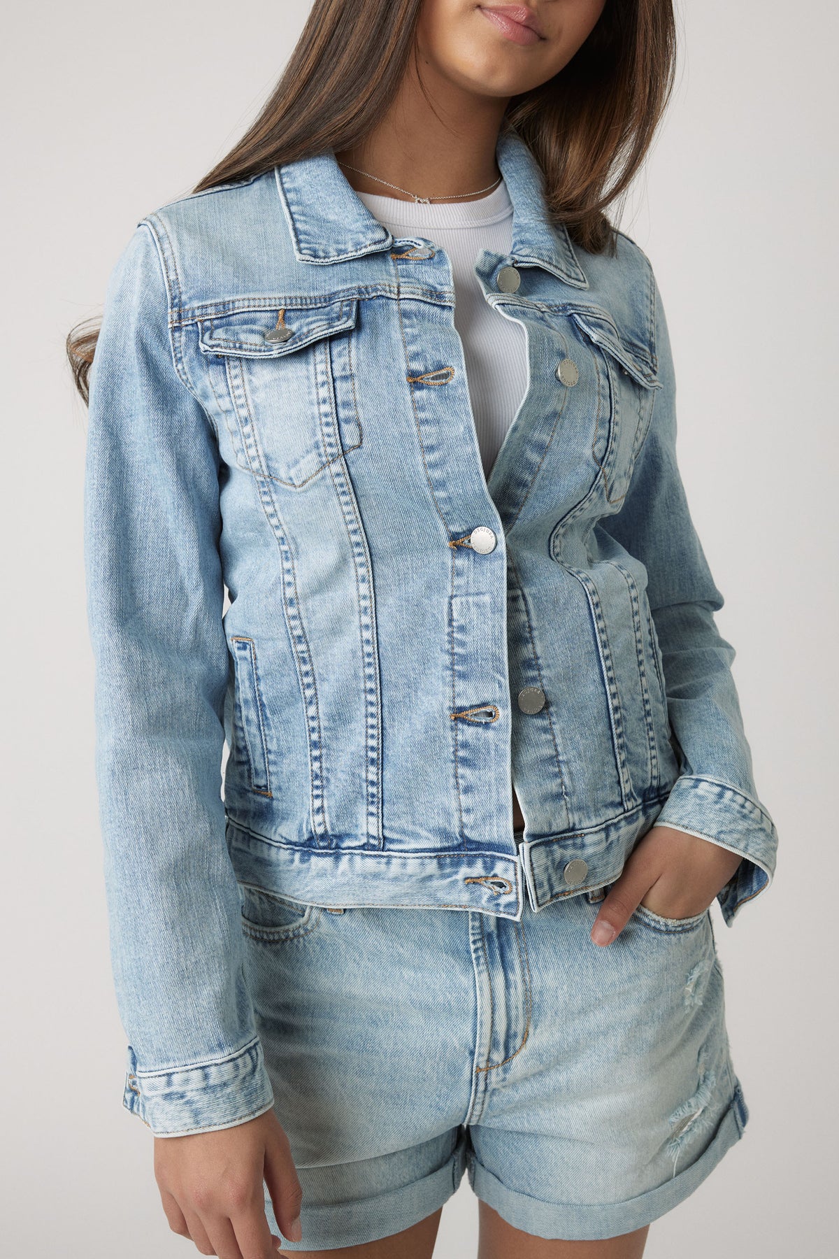 Light washed denim jacket styled with matching rolled-hem shorts for a relaxed, youthful casual look.