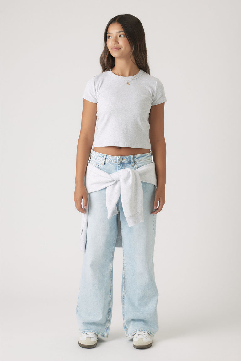 Portrait of a girl wearing Girls Hailey Wide Leg Jean in light wash with a grey sweater tied at the waist
