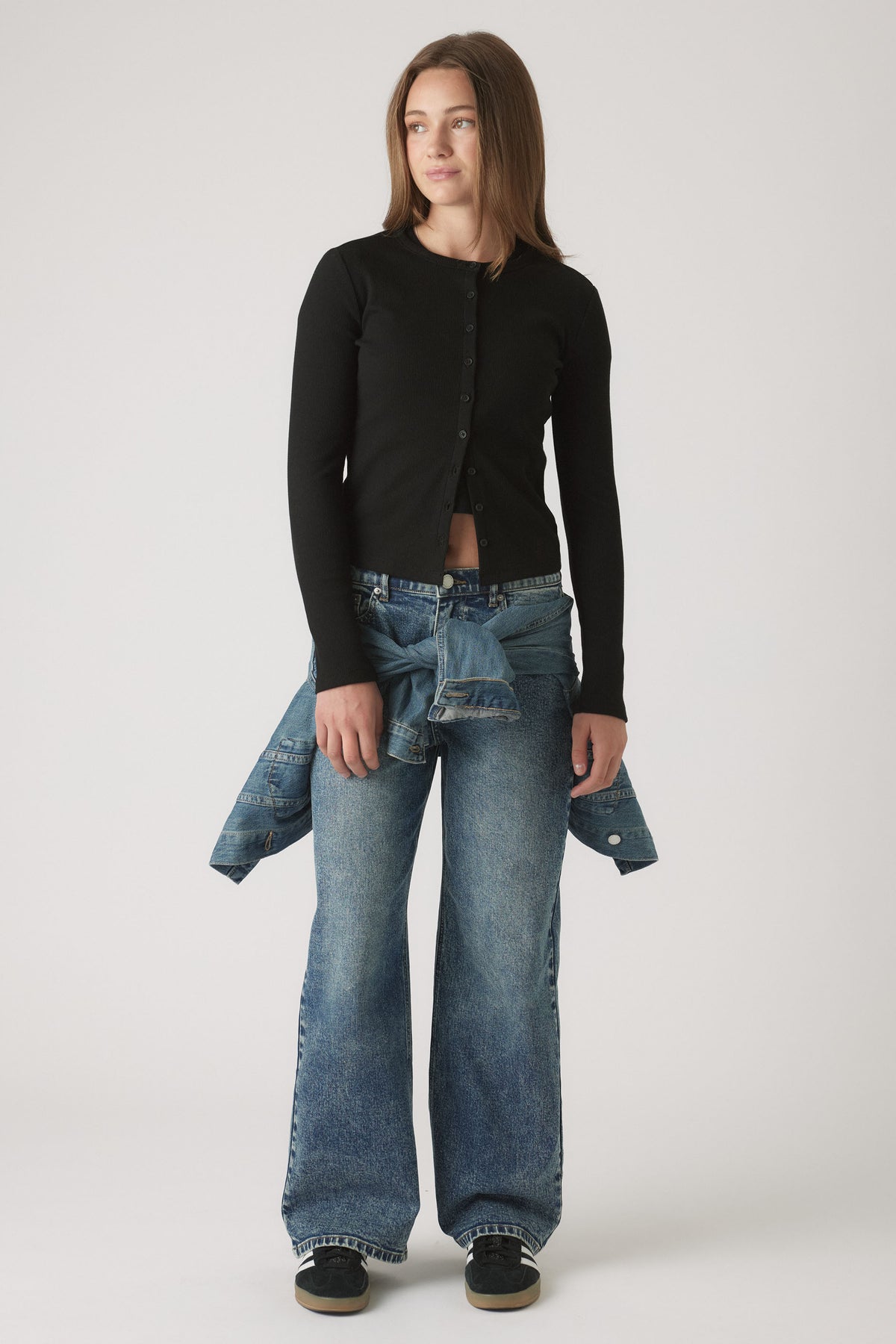 Portrait of a teen girl wearing Girls Riley Rib Long Sleeve buttoned top with denim jeans and jacket tied around waist