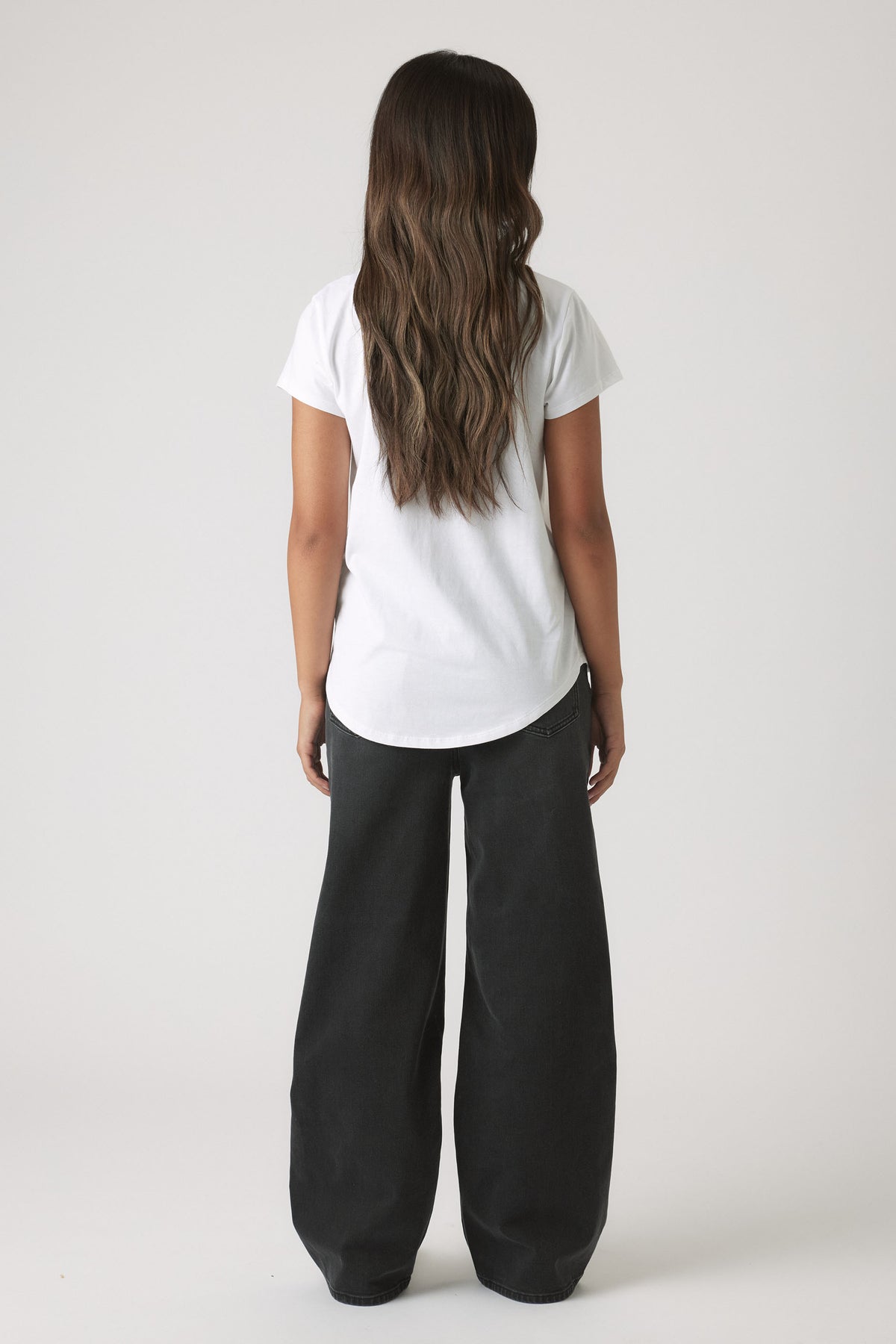 Back view of a girl wearing the Girls New York City Tee in gallery position 3 with a curved hem and regular fit