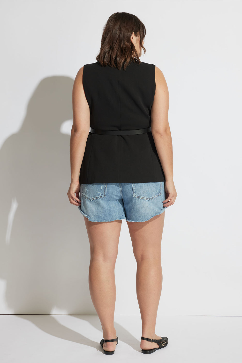 Rear view of model wearing Harper Rolled Cuff Denim Short in gallery position 5, showing relaxed fit and raw rolled hem