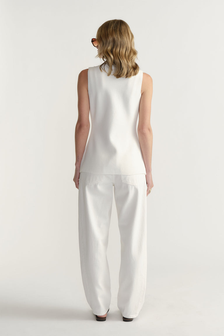 Back view portrait of model wearing Maddie Longline Knit Vest in gallery position 3 with white pants, 1880x2820px
