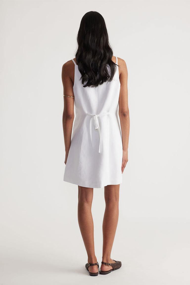 Back view of model wearing white Benne Button Front Vest Dress with tied waist in gallery position 3 portrait orientation