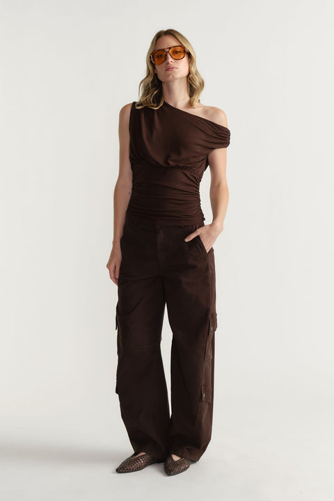 Portrait of model wearing dark brown Alexa Barrel Cargo Pant with side pockets, standing against plain light background.