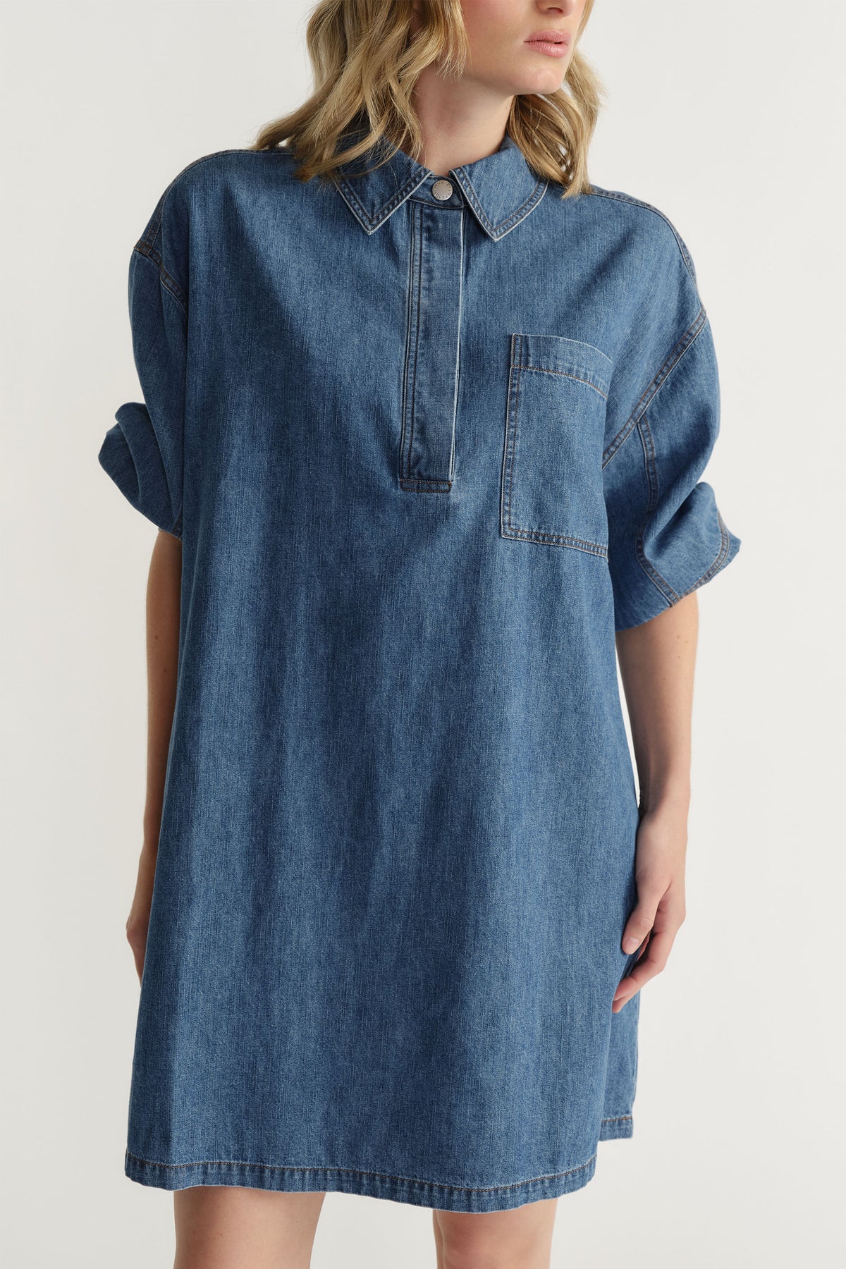 D-Luxe Chambray Stitch Dress in soft denim cotton with relaxed fit, collar, chest pocket, and rolled sleeves by Decjuba