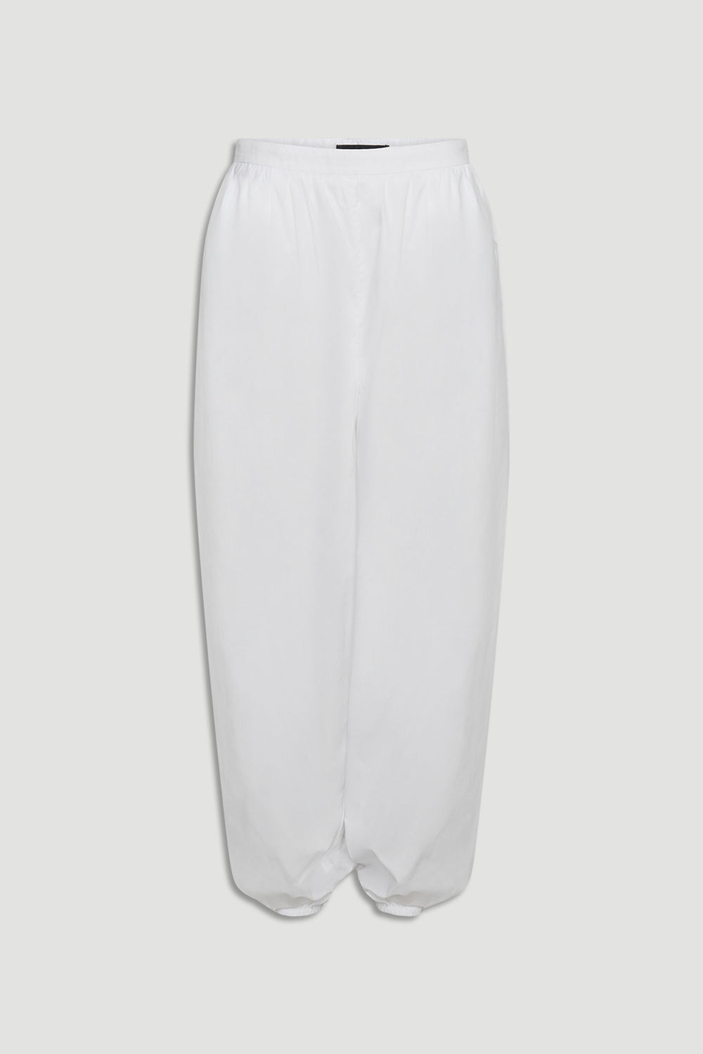 White cotton balloon pants with elastic waistband and gathered hem for a relaxed, contemporary silhouette