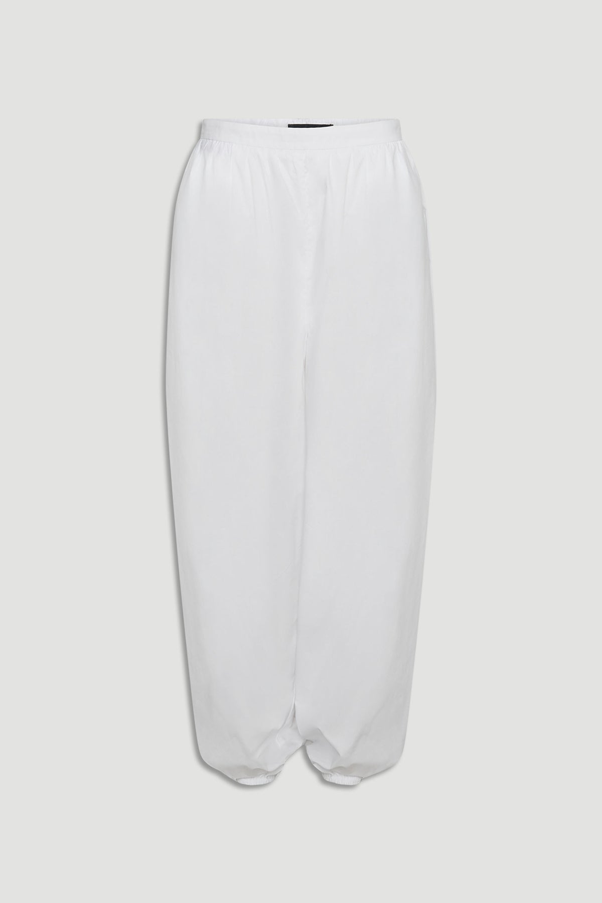 White cotton balloon pants with elastic waistband and gathered hem for a relaxed, contemporary silhouette