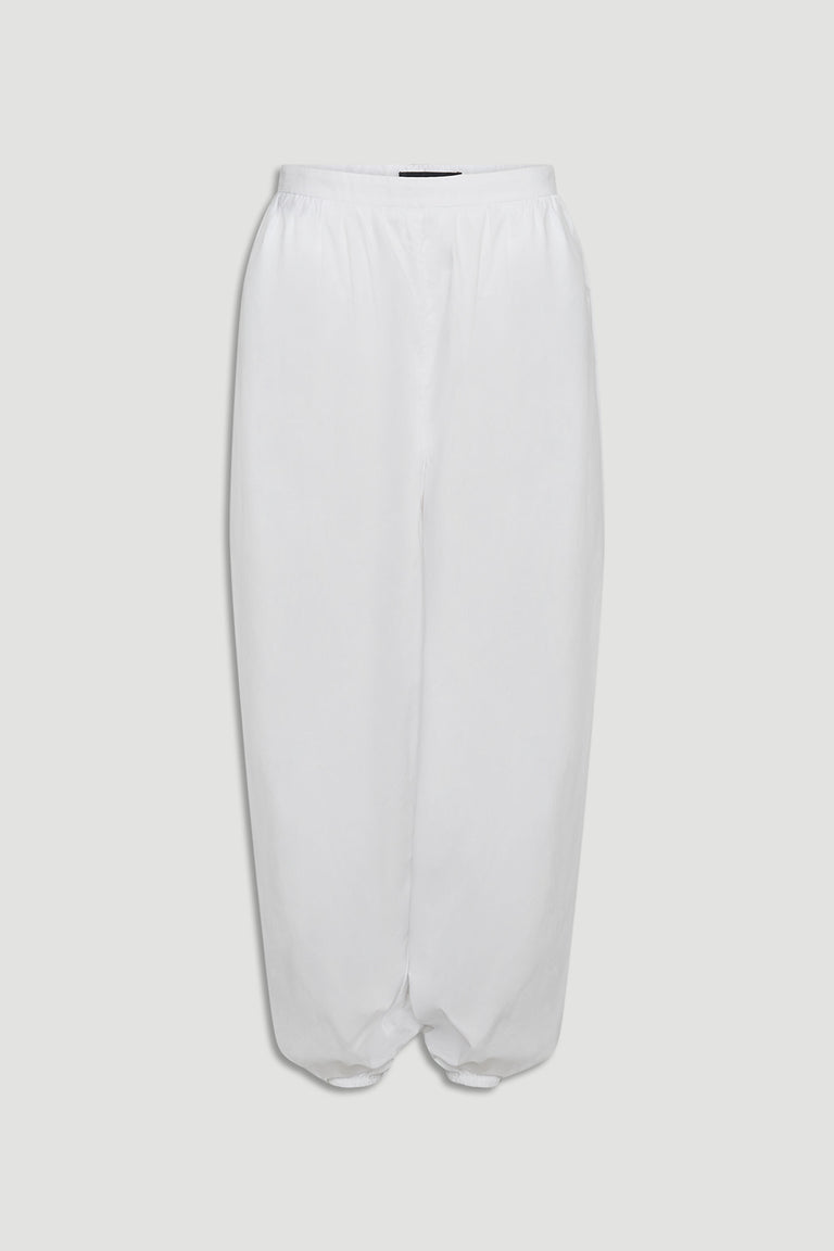 White cotton balloon pants with elastic waistband and gathered hem for a relaxed, contemporary silhouette