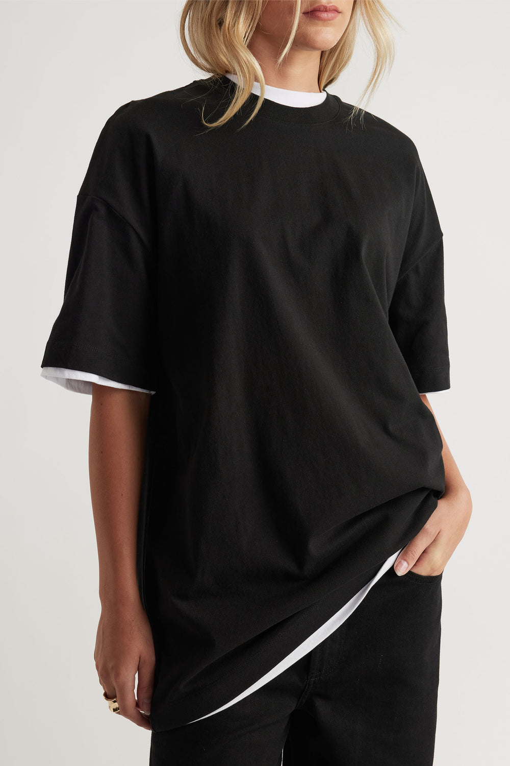 Woman wearing black Kayla Longline Tee in 100% cotton layered over white tee, styled casually by DECJUBA Australian fashion brand