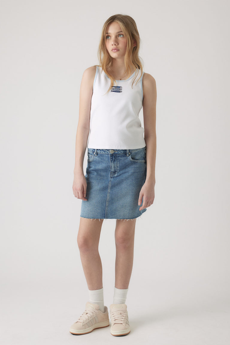 Girl wearing a white embroidered tank top paired with a casual blue denim skirt and light sneakers