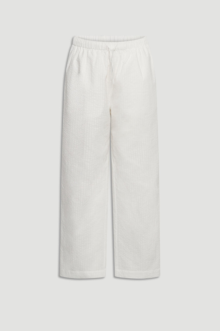 Light cream wide-leg girls pants with elastic waistband and subtle textured fabric for comfortable summer wear.