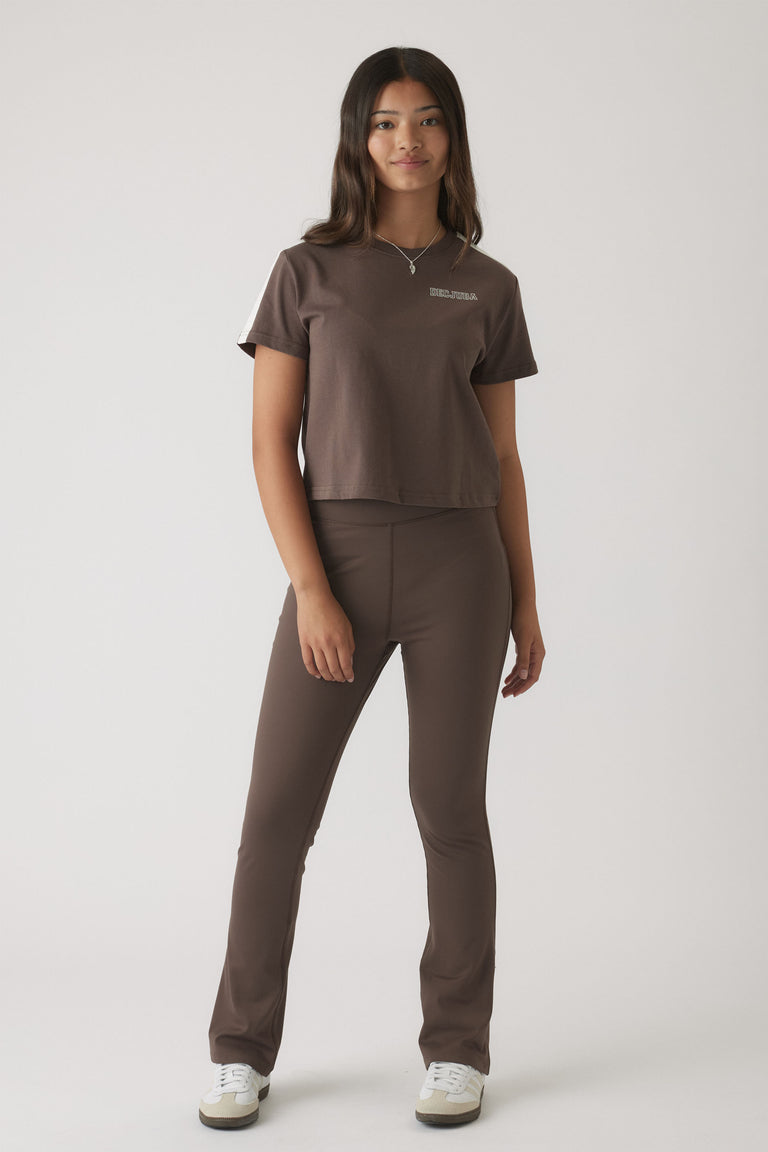 Girl wearing a relaxed mocha brown boxy tee paired with matching slim-fit pants and white sneakers