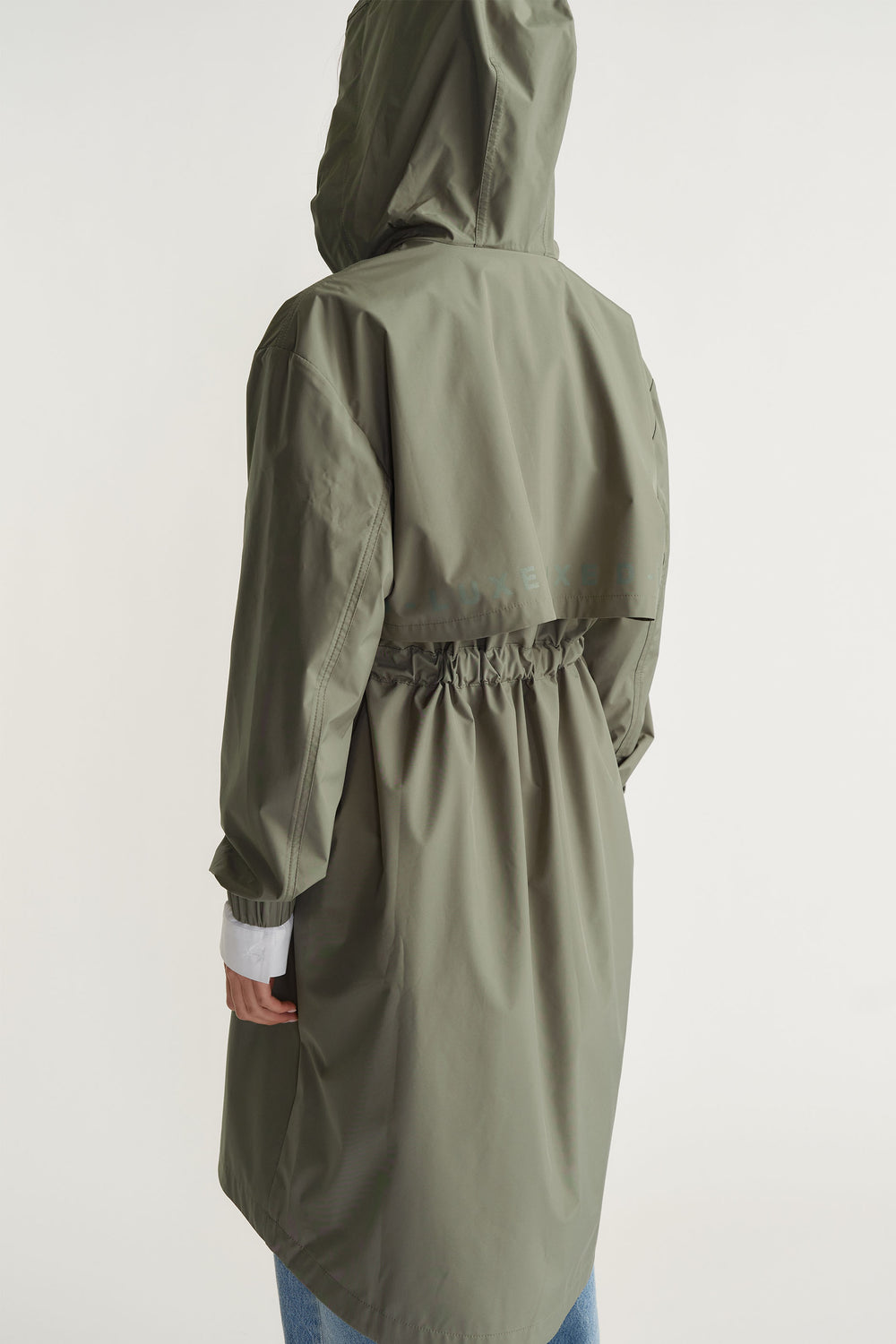 Back view of D-Luxe Rain Jacket in muted green with gathered waist and hood by Decjuba Australian fashion brand