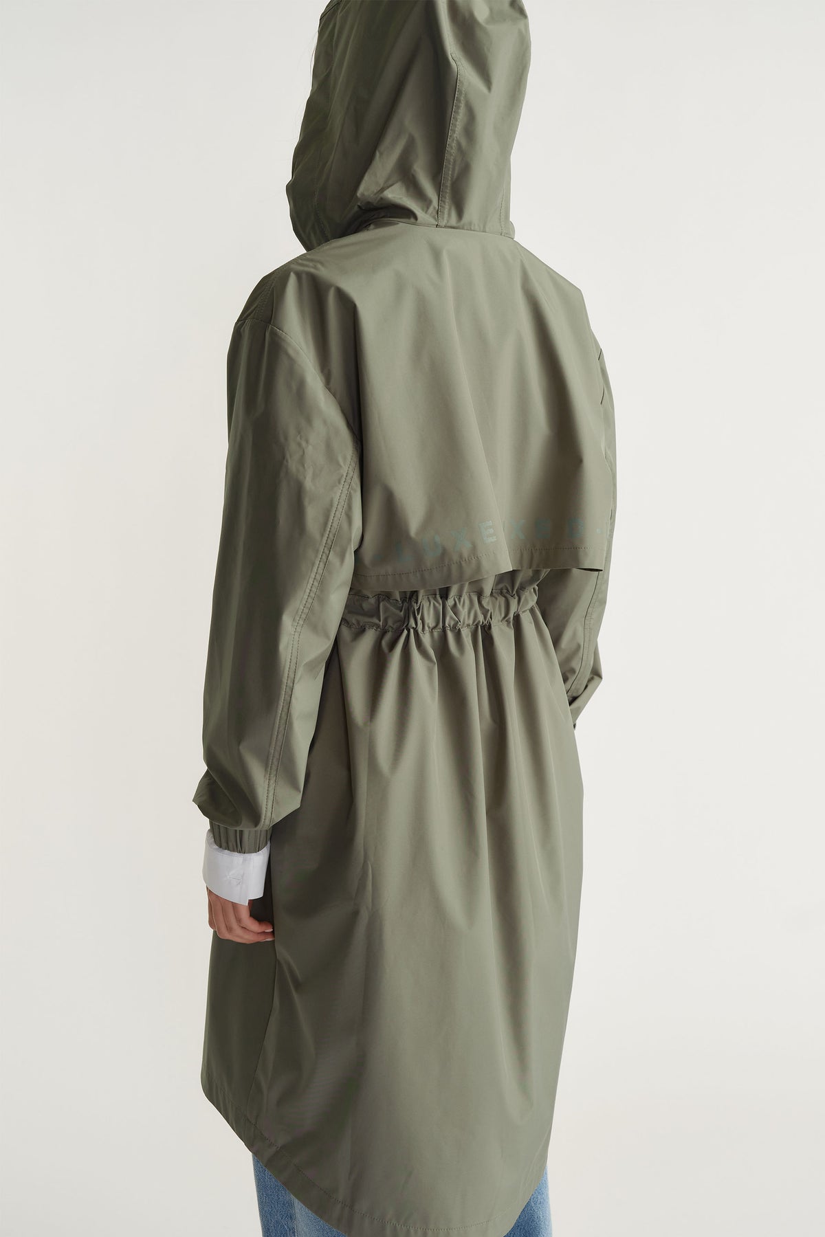 Back view of D-Luxe Rain Jacket in muted green with gathered waist and hood by Decjuba Australian fashion brand