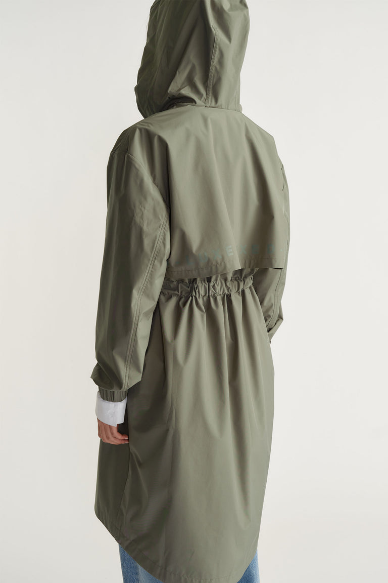 Back view of D-Luxe Rain Jacket in muted green with gathered waist and hood by Decjuba Australian fashion brand