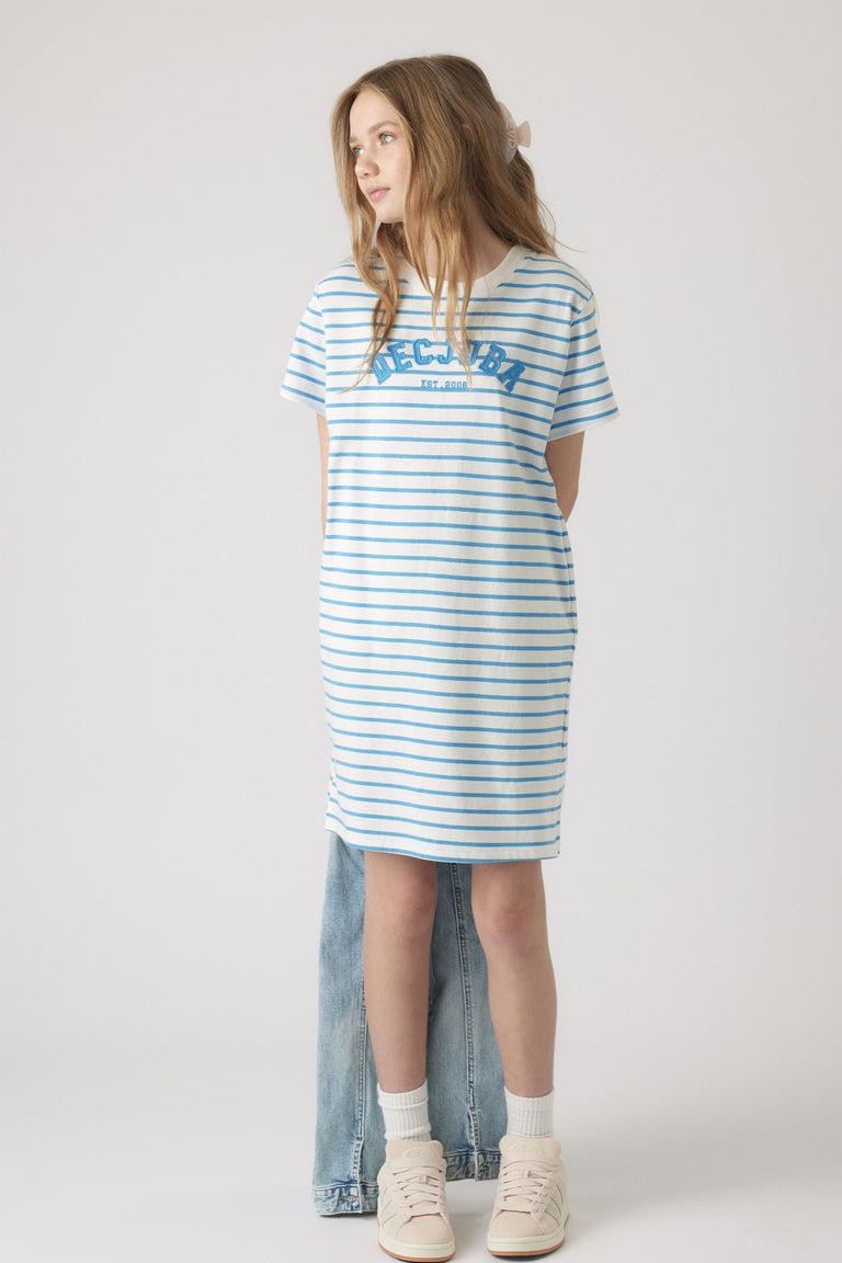 Girl wearing a relaxed striped rugby tee dress in soft blue and white, styled with light sneakers and white socks.
