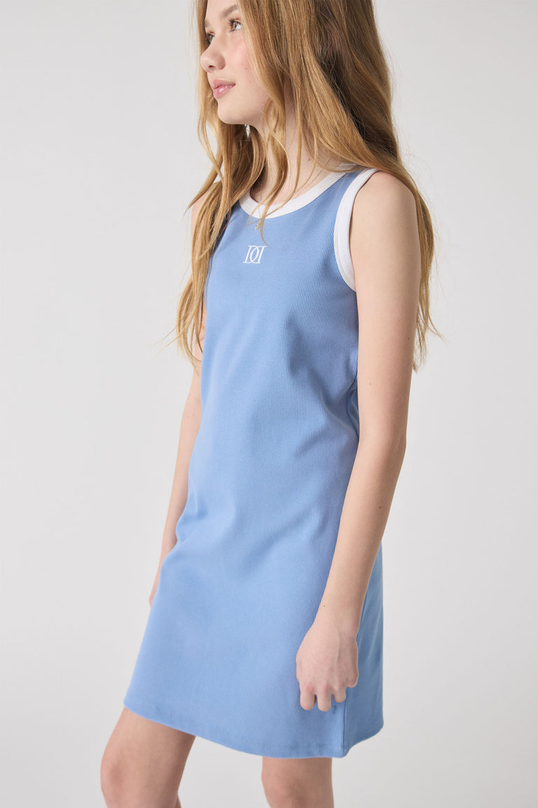 Girl wearing a sleeveless dusty blue dress with a white trim and subtle monogram detail for a fresh casual look