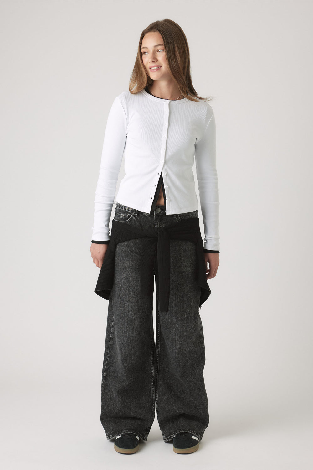 Portrait of a girl wearing the Girls Riley Rib Long Sleeve white button-through fitted top, gallery position one.