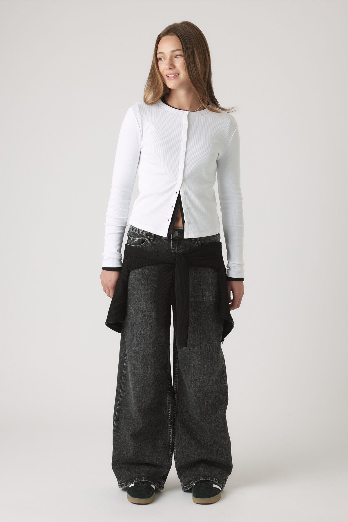 Portrait of a girl wearing the Girls Riley Rib Long Sleeve white button-through fitted top, gallery position one.
