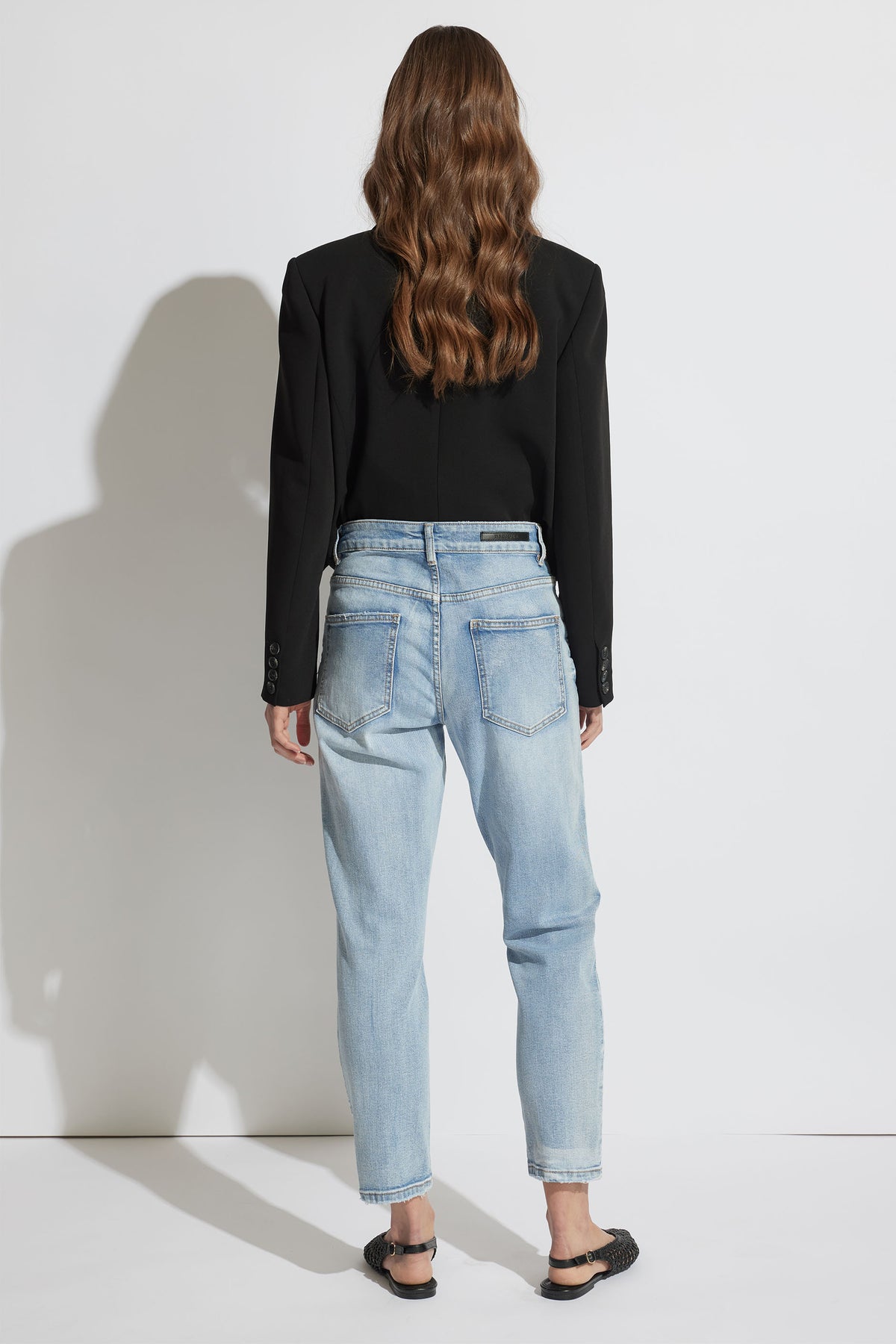 Woman modeling Alexa Girlfriend Jean in light denim, back view, gallery position 3, portrait orientation