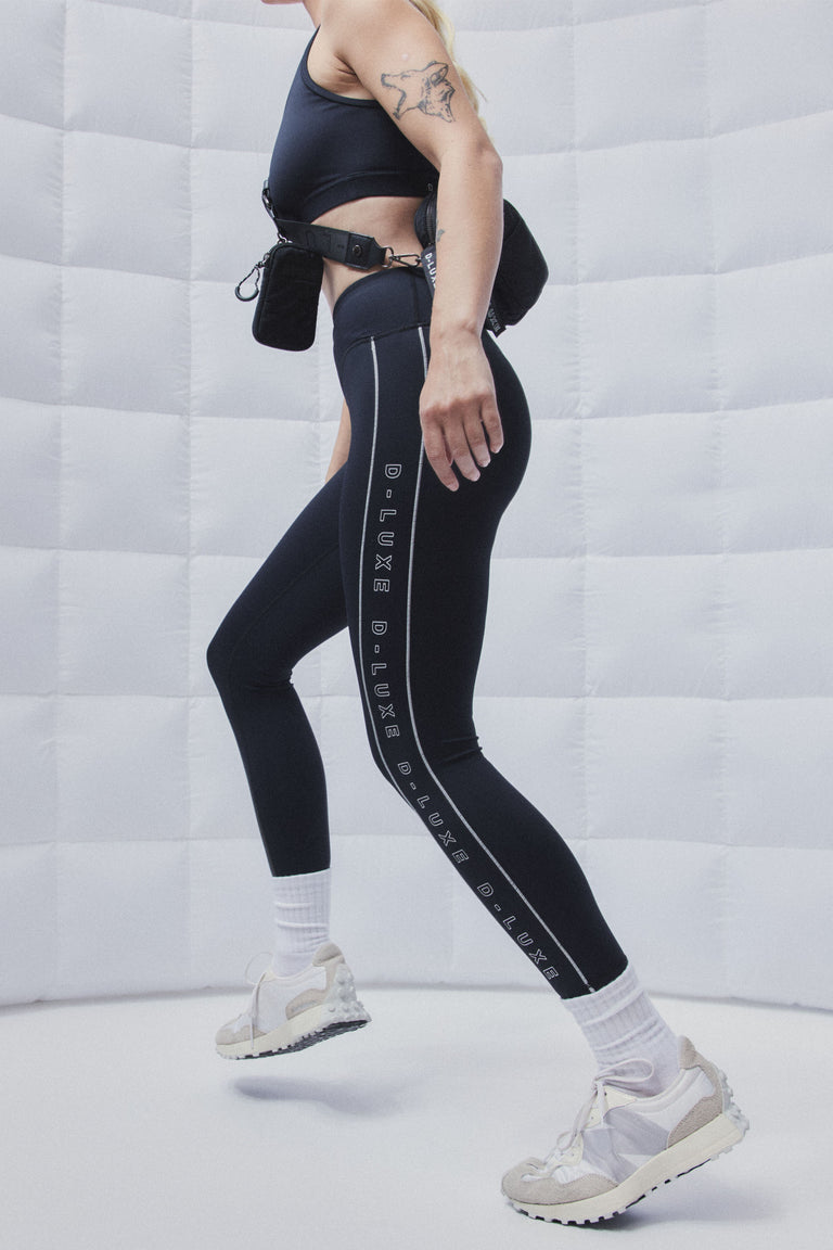 Woman wearing a black racerback sports bra, leggings and sneakers during a workout