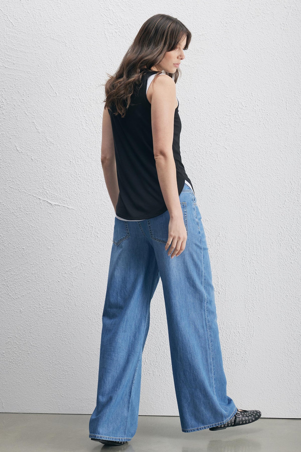 Woman wearing Pollie Soft Rib Tank with relaxed fit and high-low hem paired with wide-leg denim, gallery position 3 in portrait orientation