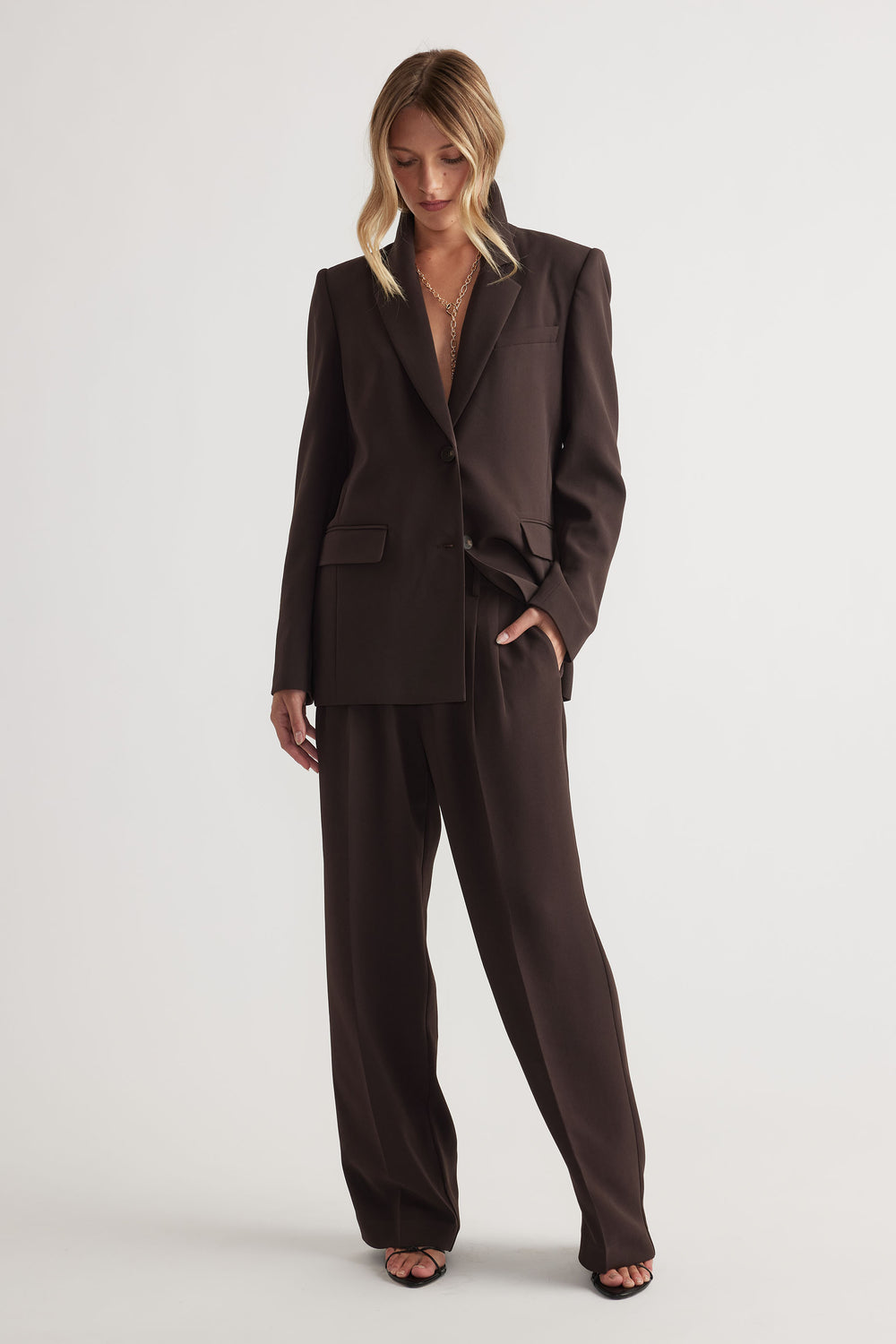 Woman wearing Carmen Tailored Blazer in dark brown with matching wide-leg pants by Decjuba Australian fashion brand