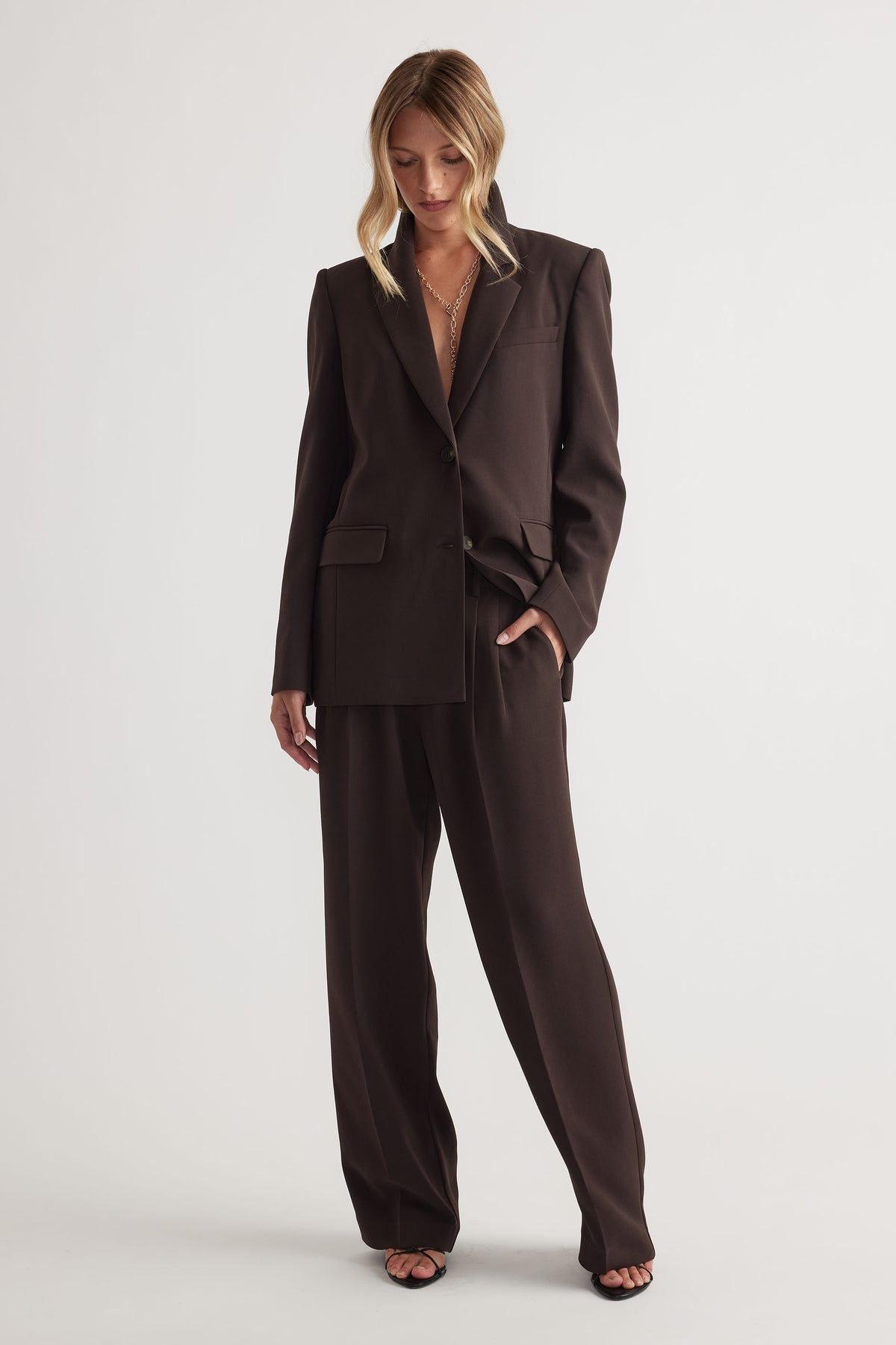 Woman wearing Carmen Tailored Blazer in dark brown with matching wide-leg pants by Decjuba Australian fashion brand