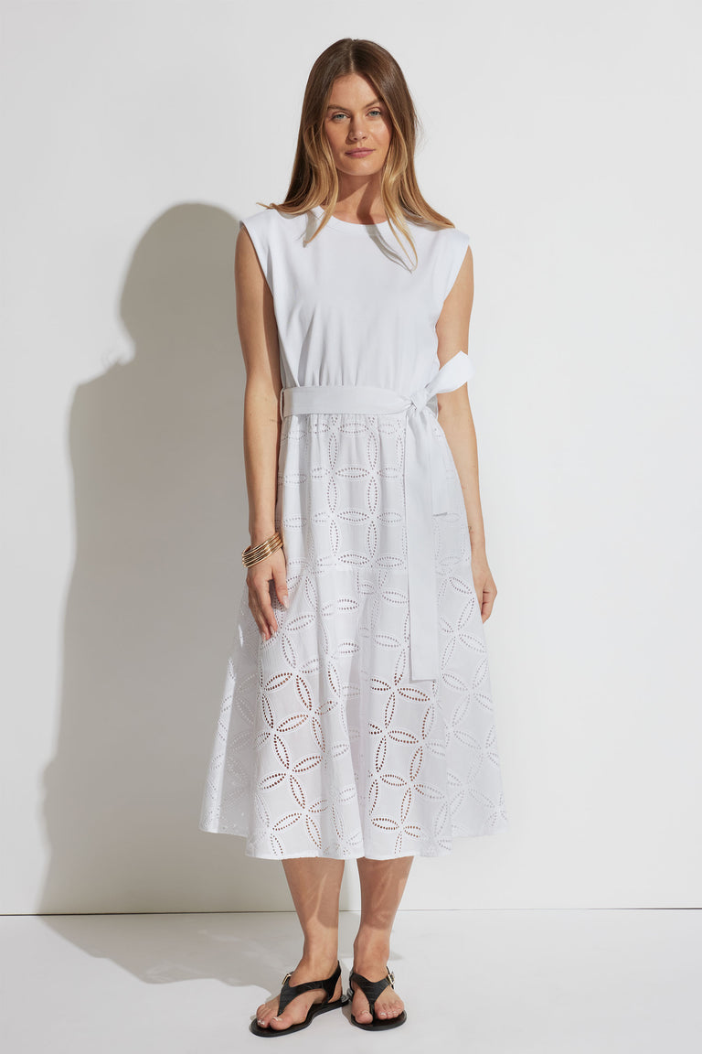 Front portrait of model wearing Eden Broderie Midi Dress with sleeveless, round neckline, and adjustable waist tie in white