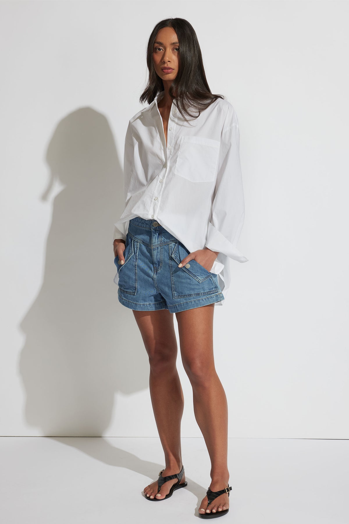 Model wearing Ella Oversized Shirt in portrait gallery shot, featuring collared neckline and front pocket, size XS shown.