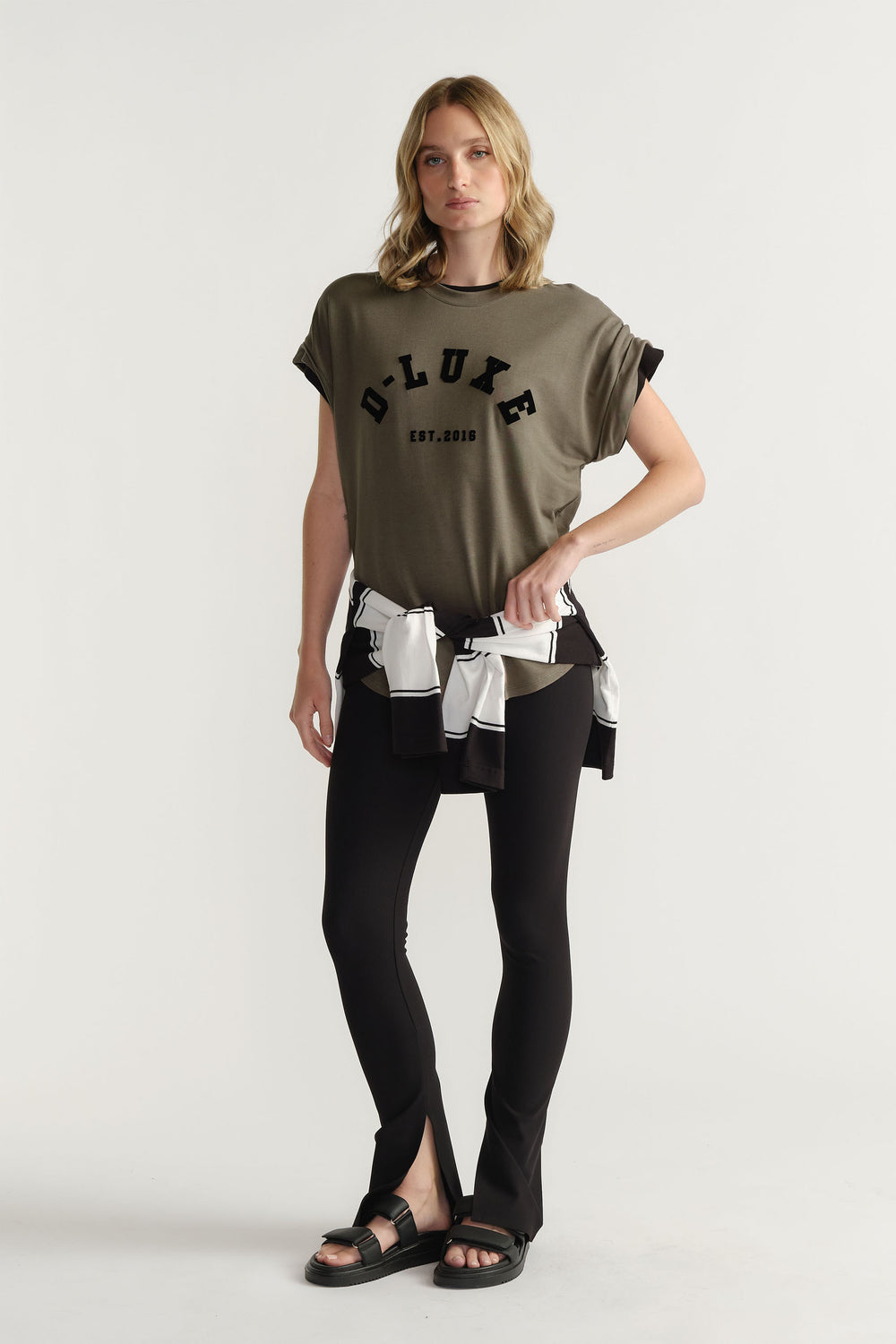 Model wearing D-Luxe Half Moon Tee with rolled sleeves and flocked logo in portrait gallery shot.