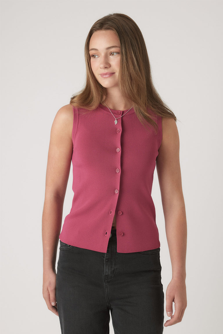 Teen girl wearing a sleeveless berry knit vest with button details, paired with black jeans and layered necklaces