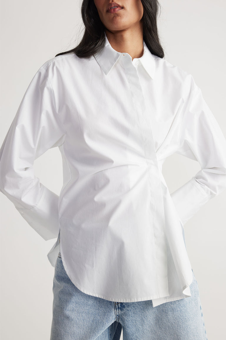 Woman wearing a white Ivy Button Shirt with a relaxed fit, tucked into light blue jeans, gallery image 3.