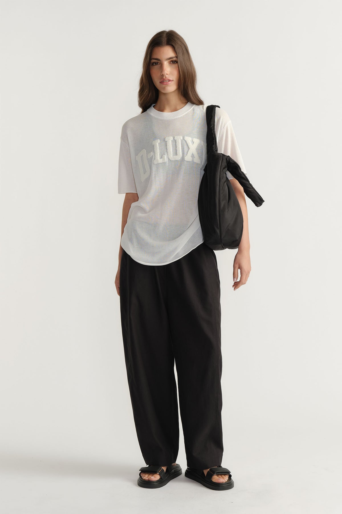 Model wearing D-Luxe Fine Knit Tee with crew neck and visible bouclé logo in portrait gallery position one.