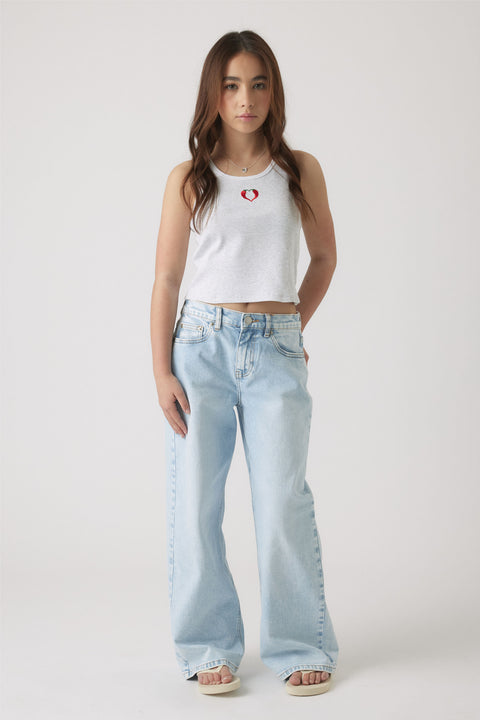 Girl wearing a light grey embroidered tank with a small red heart detail paired with loose light wash denim jeans and sandals