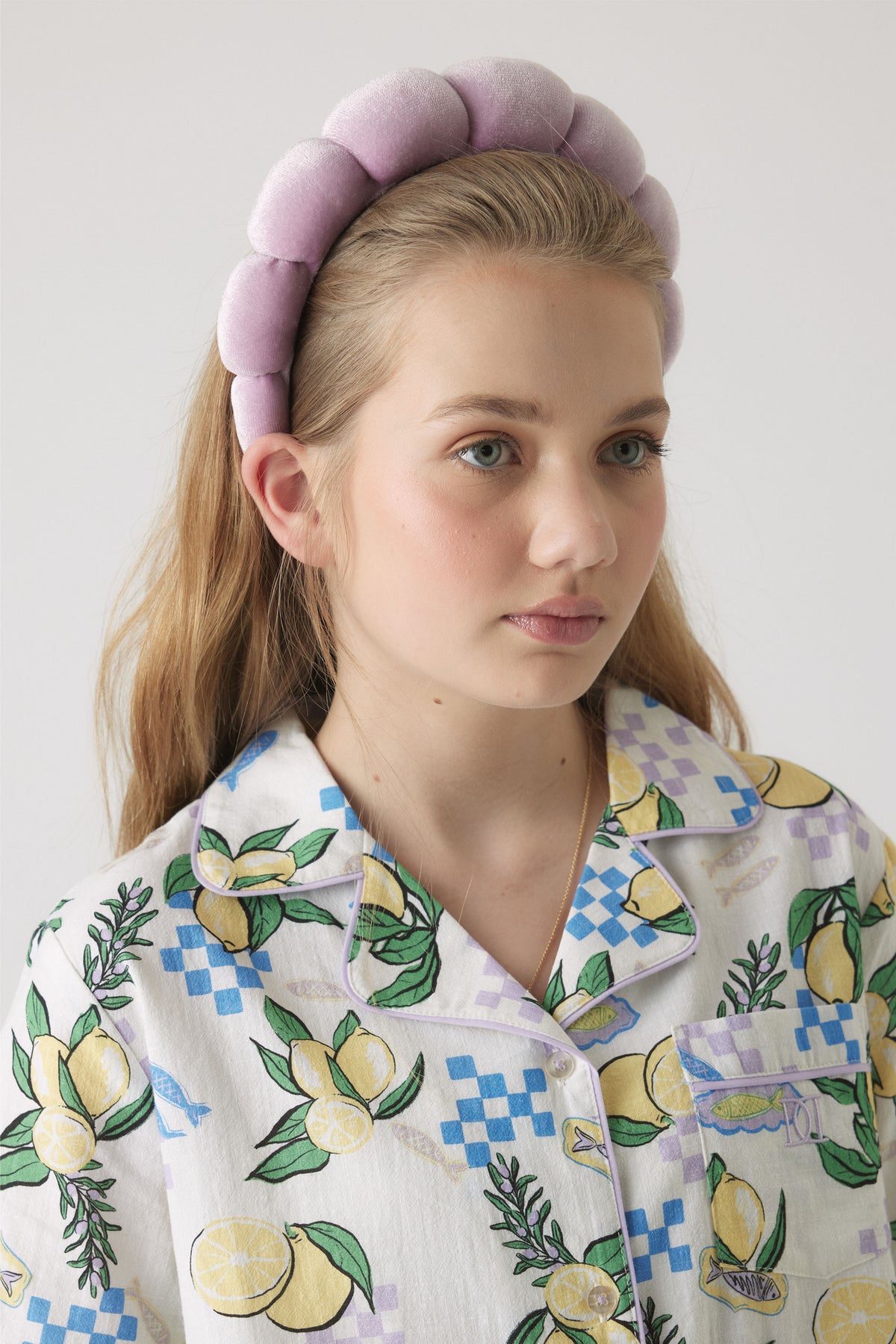 Girl wearing a lilac padded headband paired with a colorful lemon and check patterned shirt for a fresh look
