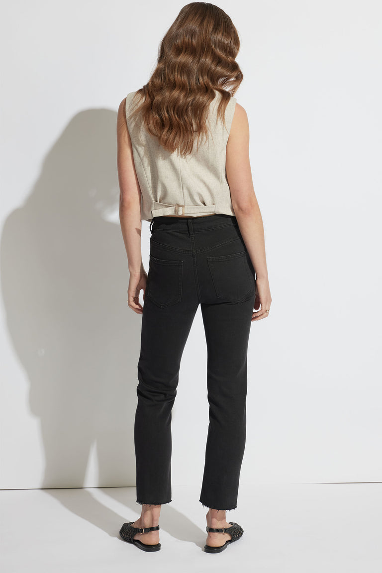 Woman wearing black Becky Straight Leg Jean with raw hem and high rise, pictured in portrait orientation, gallery position 3