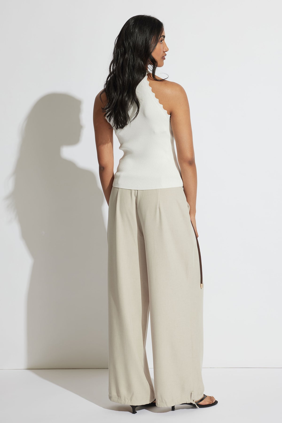 Back view of model wearing white Kai Scallop Halter Tank with ribbed fabric and scalloped edge, gallery image 3 portrait style