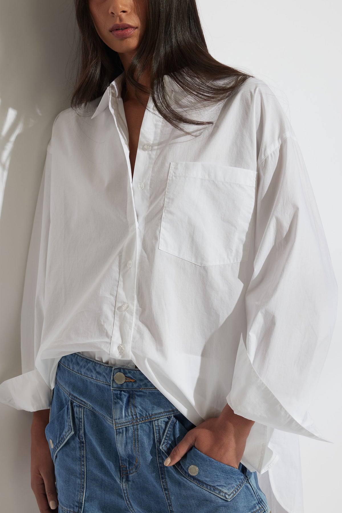 Model wearing Ella Oversized Shirt with front patch pocket in portrait gallery shot two, paired with denim bottoms.