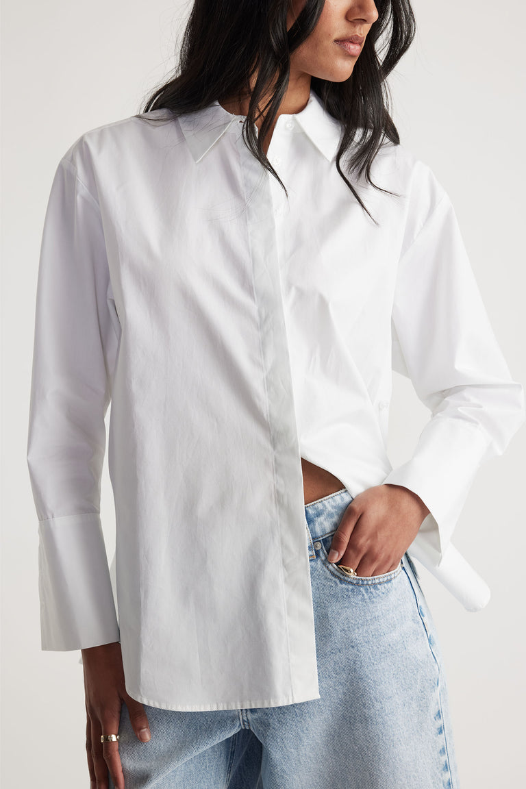Ivy Button Shirt in portrait, white collared long sleeve with concealed placket and button cuff, styled with light denim jeans