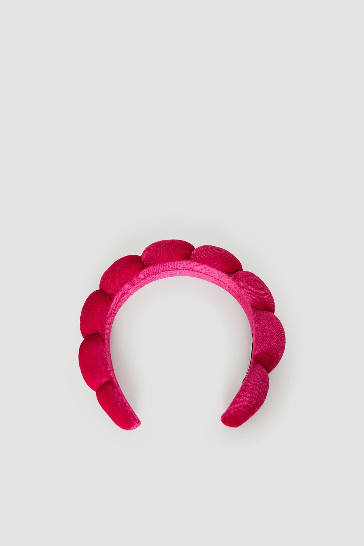 Bright pink padded headband featuring soft, rounded cushioning for a playful and comfortable girls' accessory.