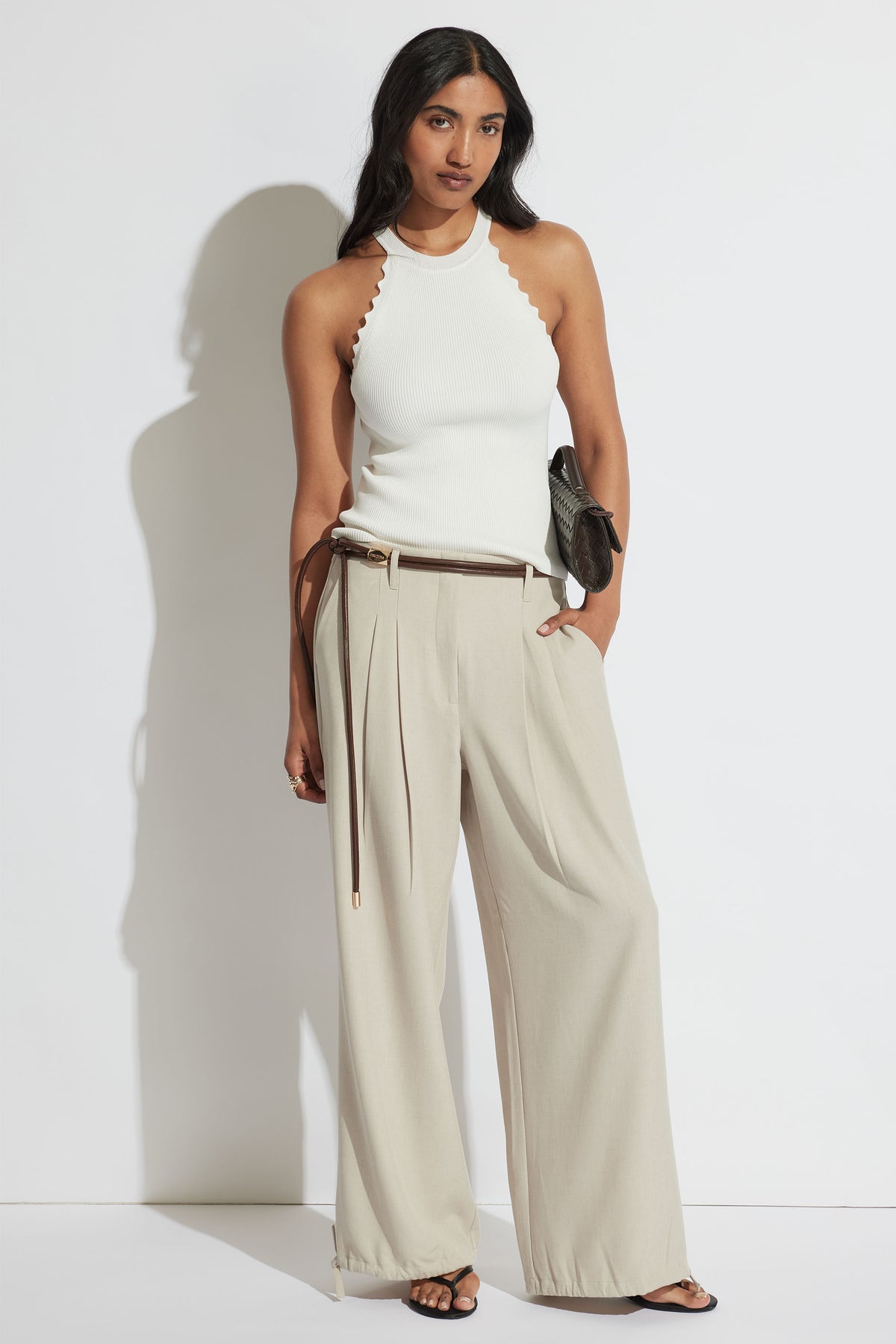 Model wearing Kai Scallop Halter Tank in portrait, featuring high neck scalloped edges and ribbed fabric, gallery position 1.