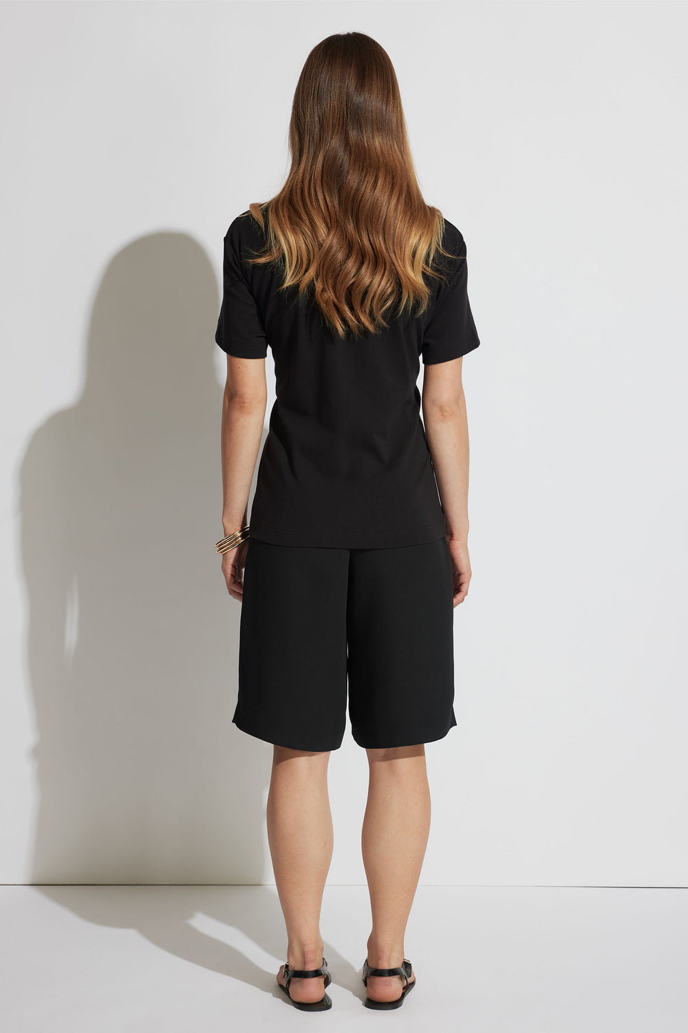 Back view of model wearing Emma Metal Detail Tee in gallery position 3, showcasing relaxed fit and short sleeves.