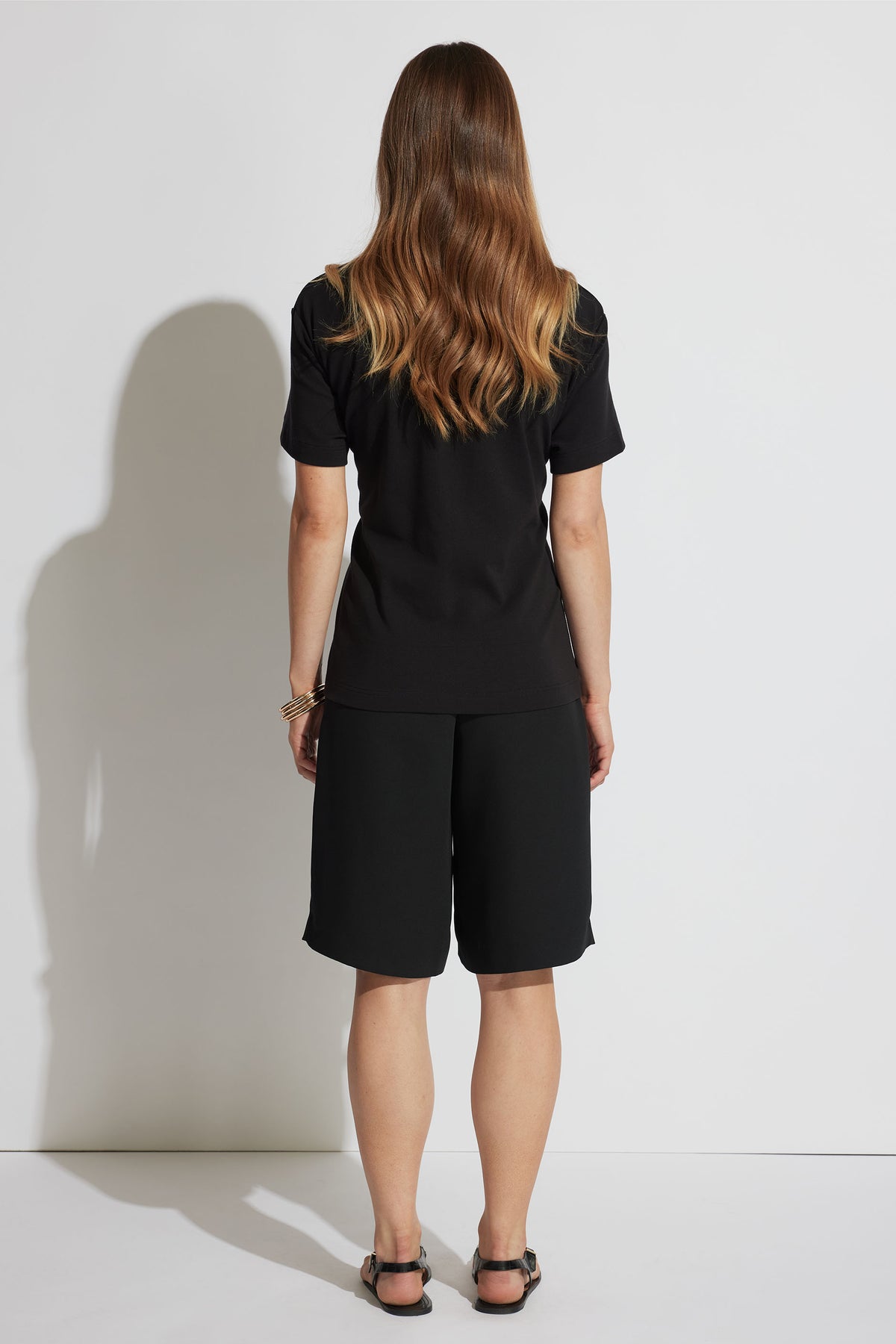 Back view of model wearing Emma Metal Detail Tee in gallery position 3, showcasing relaxed fit and short sleeves.
