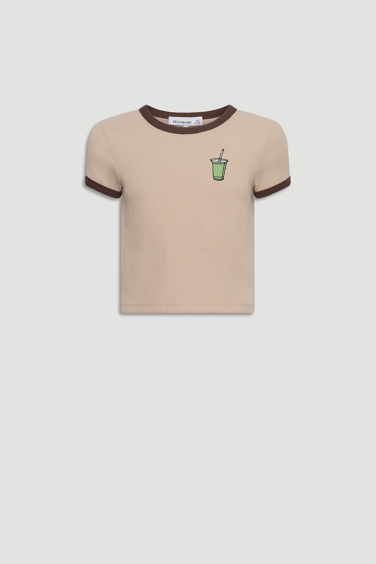 Beige cropped tee with contrasting brown trim and a small green smoothie graphic on the chest for a playful touch