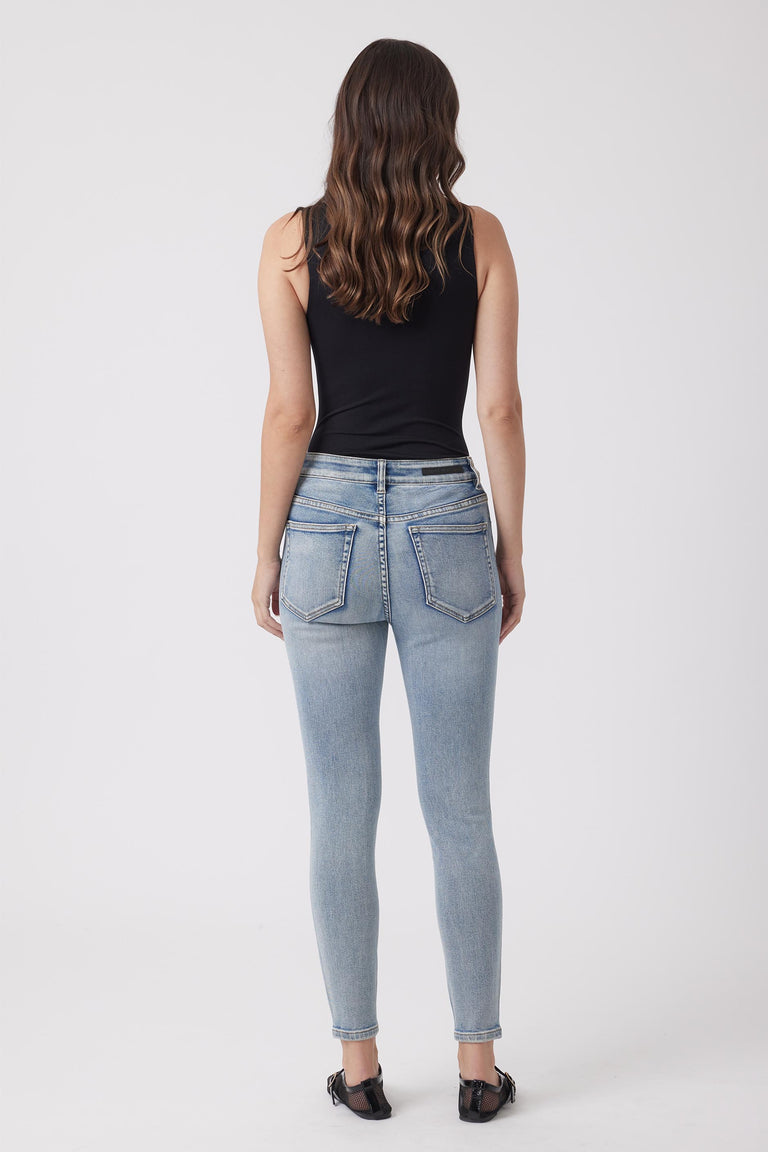 Light wash high-rise skinny jeans styled with a black sleeveless top and casual black shoes for everyday wear.