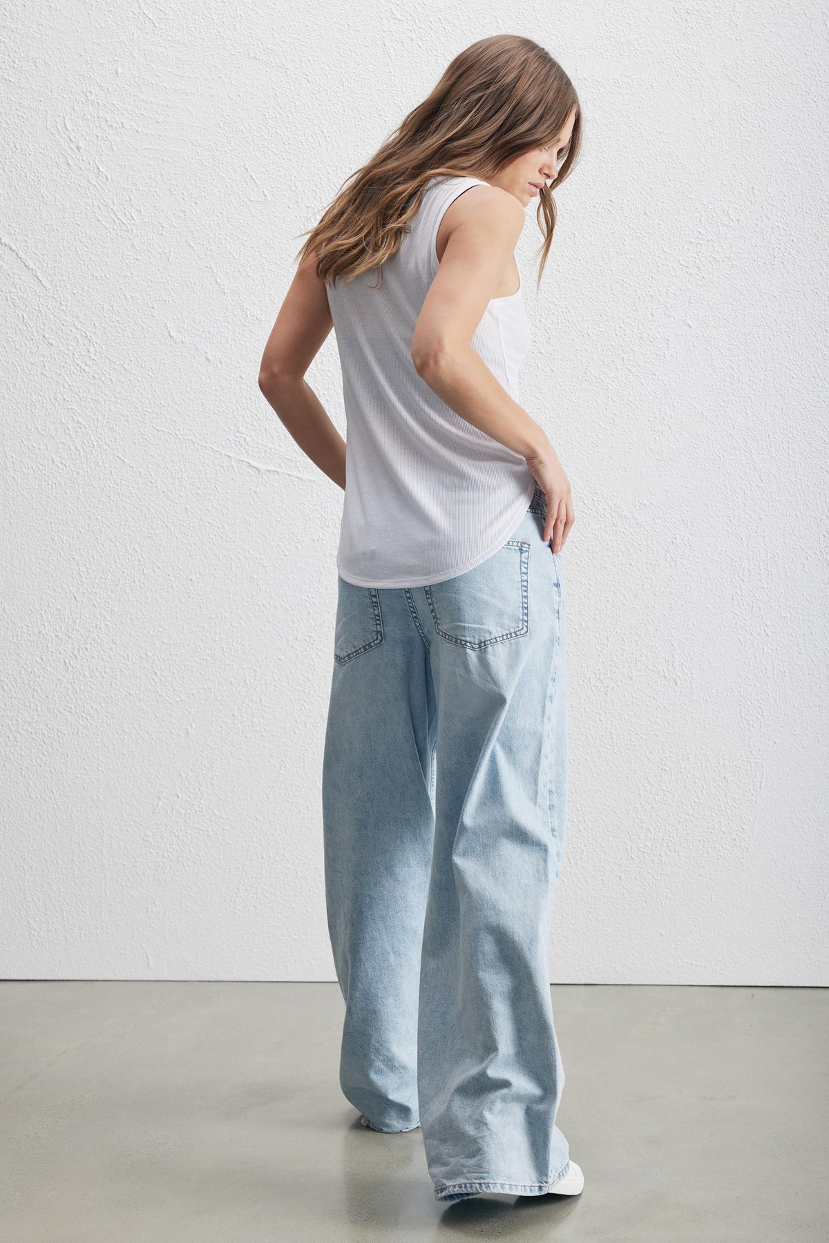 Pollie Soft Rib Tank in white shown from back, relaxed fit with curved high-low hem, gallery position 3 portrait view