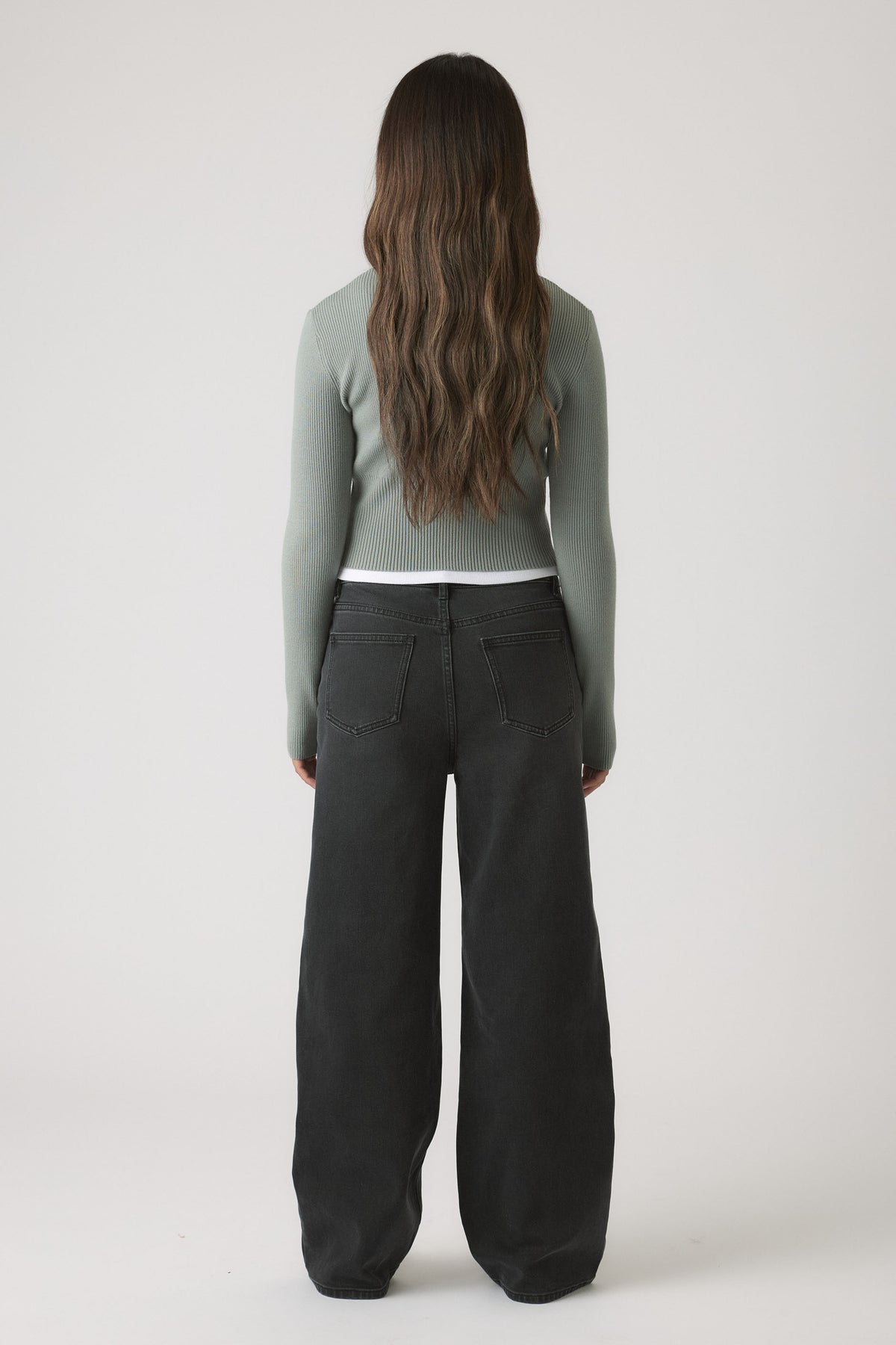 Girls Matilda Zip Up Knit in muted green with fitted silhouette, styled with wide-leg black denim for versatile casual wear by DECJUBA Australian brand