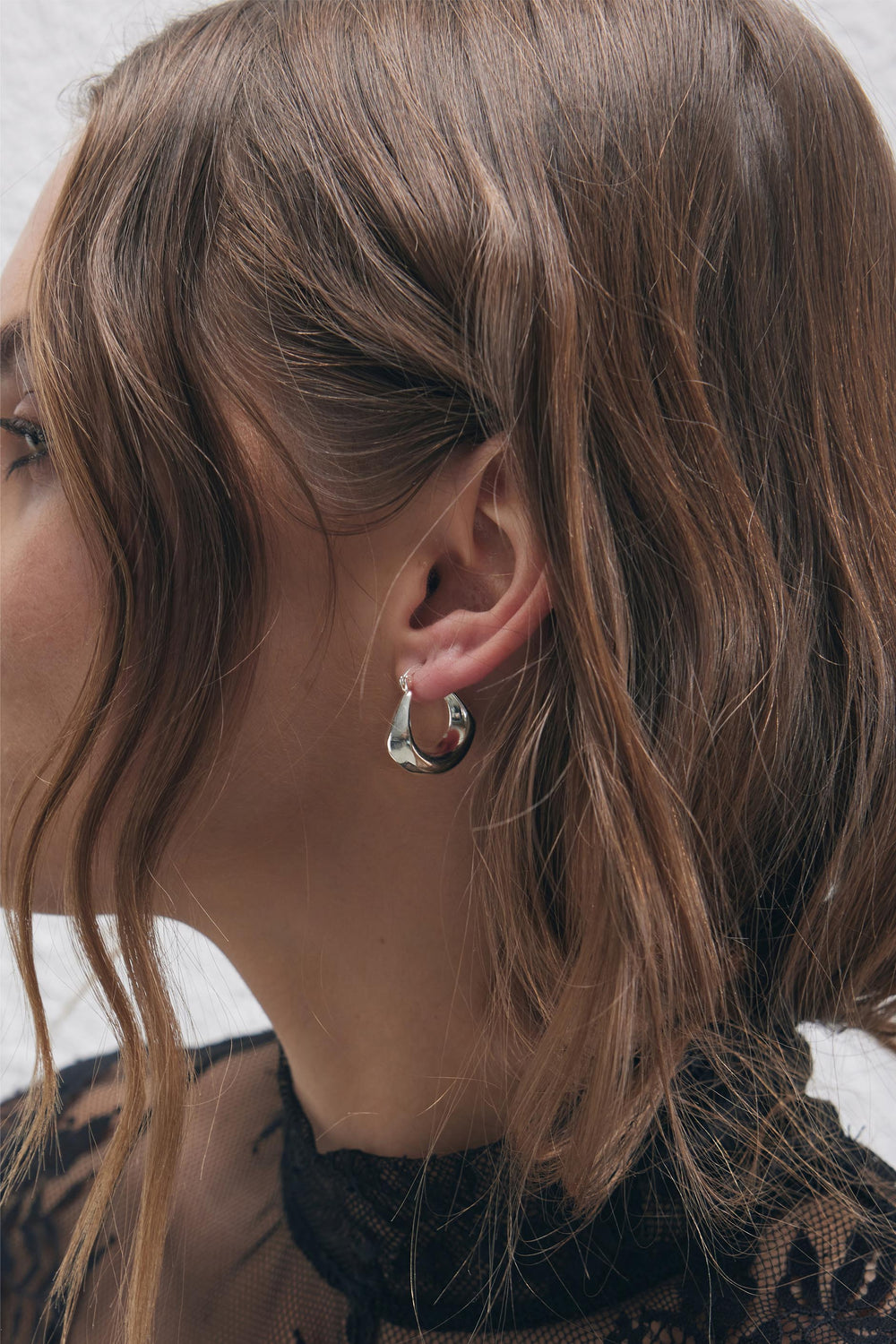 9ct Hanging Hoop Earrings in polished silver tone worn by woman with soft waves, by DECJUBA Australian fashion brand.