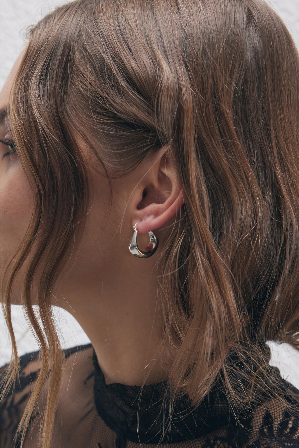 9ct Hanging Hoop Earrings in polished silver tone worn by woman with soft waves, by DECJUBA Australian fashion brand.